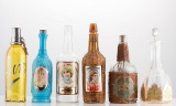 Group of six early Saloon Bottles, three of which have colored glass labels with ladies, one with wi