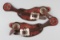 Ornate pair of two piece floral Straps with raised silver conchos and Clint Mortenson engraved sterl