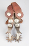 Pair of silver overlaid Spurs, single mounted with engraved domed conchos, chap guards, early straps