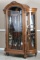 Fancy antique, double curved glass, oak Gun Cabinet, custom fitted for 13 long guns & 8 Revolvers.