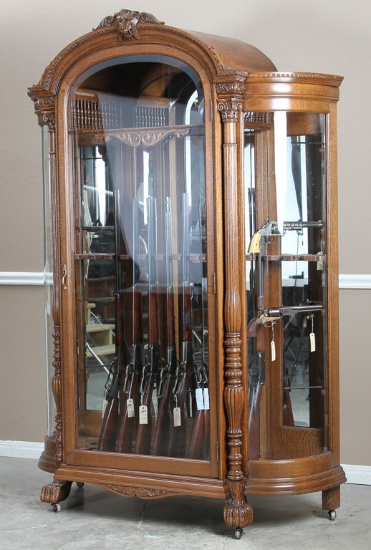 Fancy antique, double curved glass, oak Gun Cabinet, custom fitted for 13 long guns & 8 Revolvers.