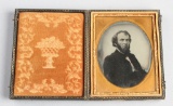 Circa 1850, 1/4-plate Ruby Ambrotype of a bearded gentleman in a dark frock coat, shown in a plain g