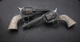 An elaborately engraved pair of Colt SAA Revolvers, SN 165061 matches on the frame, trigger guard an
