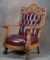 Massive antique oak claw foot Arm Chair, circa 1900, with ornate relief carved back, upholstered in