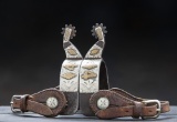 Pair of single mounted Spurs, attributed to Frank Bradney, with wide heel band and heavy hand engrav