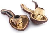 Two vintage carved Pipes with hand holding skulls; One has its original case and measures 4 1/2