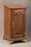 Custom oak Chair Side Stand with full length raised panel door, brass hardware and fancy brass feet.