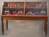 Antique slant front oak and glass, floor model Showcase, circa 1910, manufactured by The Kinley Show