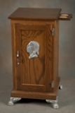 Oak Slot Machine Stand with single door, metal Indian Head on front and metal feet. Stand was custom