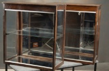 Matched pair of wooden and glass counter top Showcases with glass shelves, mirrored backs and floors