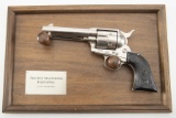 A wall mounted non-firing Revolver on wooden hanging mount, titled 
