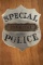 Stock silver tone â€œSPECIAL POLICEâ€ marked Badge with applied banner in center marked â€œSERGEANT