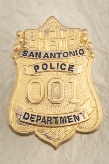 Large gold tone Shield Badge marked â€œSAN ANTONIO POLICE DEPT/ # 001â€, measures 3â€ T x 2 1/8â€