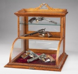 Very unique oak, curved glass, table top model Showcase with bronze label on front marked 