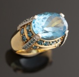 Ladies 18kt yellow gold custom oval Blue Topaz ring containing 46 round brilliant cut blue diamonds.