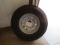 369. UNUSED 235/85R/15 TIRE ON 8 BOLT TRAILER RIM, TAX