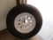 370. USED 235/80R/16 TIRE ON 8 BOLT TRAILER RIM, TAX