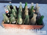 Collectible glass soft drink bottles in vintage wooden tray