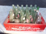 Collectible glass soft drink bottles in vintage wooden tray