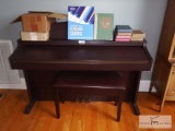 Roland digital piano with stool and music books