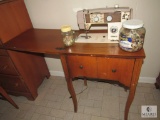 Vintage Fleetwood sewing machine in wood cabinet with wooden stool