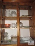 Contents of kitchen cabinet includes glass bowls canister bowls and plates