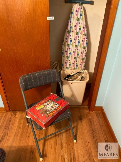 Contents of Closet Including Ironing Board and Santas of the World