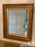 Mirror with gold-colored wooden frame