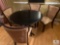 Black Round Dining Table with Four Tan and Brown Chairs