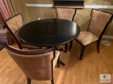 Black Round Dining Table with Four Tan and Brown Chairs