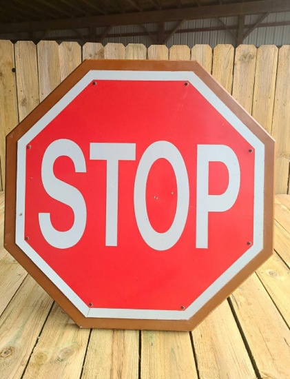 Large steel stop sign on wooden backer.