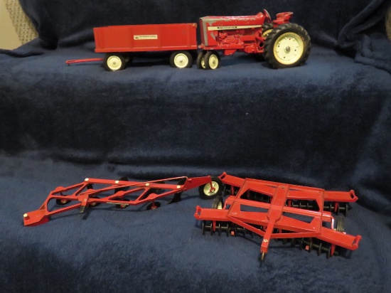 Well-used toy tractor, wagon, disc, plow