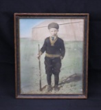 Antique color portrait photo of a boy with his rifle.