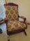 Wooden Rocking Chair Ornate Curled Top Carved Sides, Grooved Arms