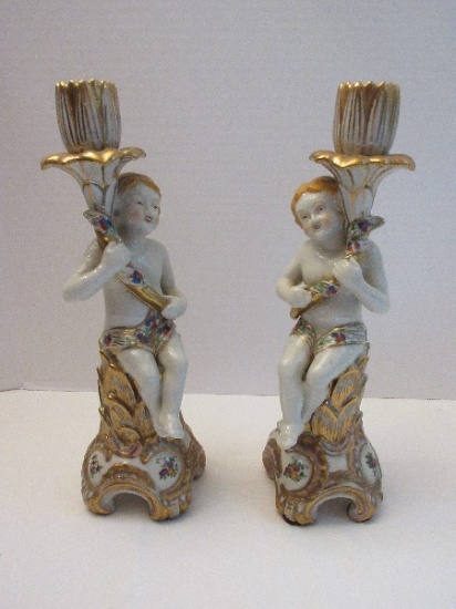 Pair - Semi-Porcelain Putti Renaissance Style Figural Candlesticks Holding Stem Flower Buds