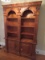 Tall Wooden Shelving w/ 2 Lower Doors, Grooved Columns, Panel Motif, 4-Tier w/ Wave Trim
