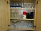 (K) DOUBLE WIDE CABINET FILLED W/ MISC. GLASSWARE, BATMAN GLASSES, MICKEY MOUSE GLASSES, RONALD