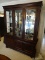 MAHOGANY BASSETT CHINA CABINET. HAS 2 UPPER BEVELED GLASS DOORS AND 2 SIDE LIGHTS. HAS INTERIOR