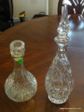 2 PRESSED GLASS DECANTERS. BOTH HAVE STOPPERS. 1 IS 10'' TALL AND THE OTHER IS 15.25'' TALL