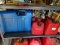 (G) SHELF LOT OF GAS CANS THAT INCLUDES A BLUE 6 GAL. CAN, A RED 2 GAL. CAN, AND A RED 2.5 GAL CAN