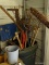 (S) CORNER LOT BY DOOR. TRASH CAN FILLED WITH GARDEN AND HAND TOOLS. INCLUDES A 2 MAN SAW, RAKE,