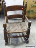 ANTIQUE MIXED WOOD HAND TURNED CHILD'S ROCKER. HAS PEGGED BACK SUPPORTS AND SPLIT OAK WOVEN SEAT: