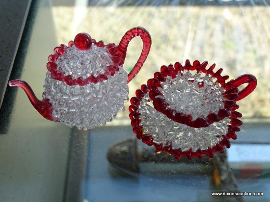 (WR) HAND BLOWN GLASS TEAPOT AND CUP AND SAUCER. 1.5" TALL. GOOD CONDITION.