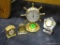 (ROW 2) LOT OF 3 MINIATURE CLOCKS AND A SHIPS WHEEL STYLE THERMOMETER.