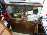 (TABLES) LARGE AQUARIUM ON STAND: 3'x1'x4'. STAND HAS DOORS FOR EXTRA STORAGE. HAS LIGHT AND HOSE