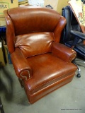 (R4) FAUX LEATHER ROCKING RECLINING ARM CHAIR. HAS BRASS STUDDING ALONG THE ARMS AND SIDES: