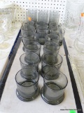 (TABLE) LOT OF SMOKED GLASS FOOTED GLASSES: 12 HIGHBALL GLASSES. 6 WATER GLASSES.