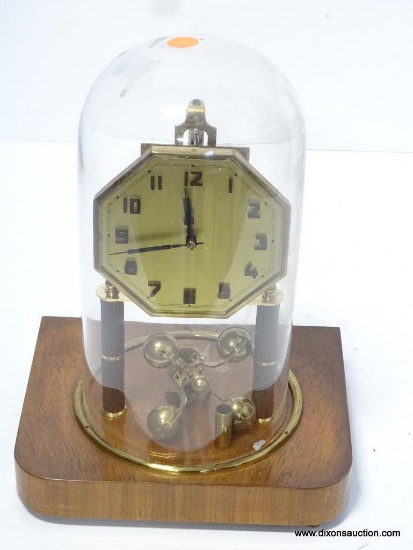 GERMAN ANNIVERSARY CLOCK UNDER DOME WITH A WOODEN BASE. MEASURES 12"T X 8.75"W RETAIL PRICE $225.