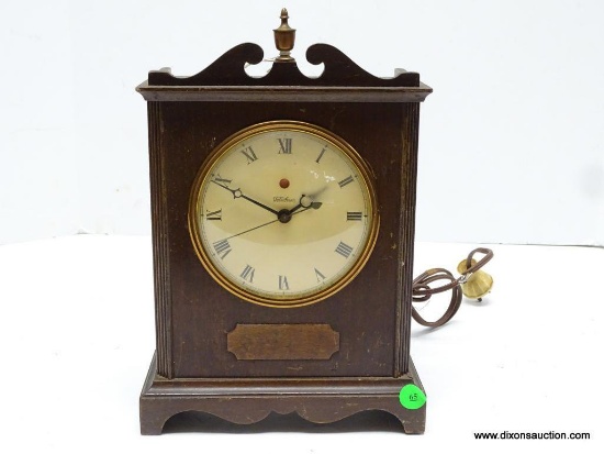 TELECHRON ELECTRIC SHELF CLOCK. MAHOGANY CASE WITH SCALLOP CUT SKIRT AT THE FRONT, BROKEN ARCH