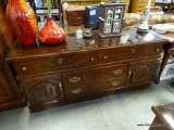 (A4) DARK PINE FINISH TRIPLE DRESSER. BRASS HARDWARE WITH WHEAT CARVED DECORATIONS. 66X17X30.5 HAS A